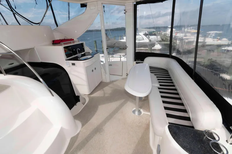 Slide: The Image of Luxurious 2007 Meridian 459 Motoryacht interior with seating, table, and kitchenette, overlooking marina. - 4