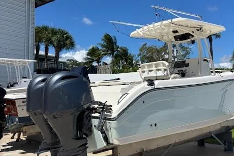 Slide: The Image of 2018 Century 2600 Center Console boat with dual outboard motors, docked under a clear blue sky. - 21