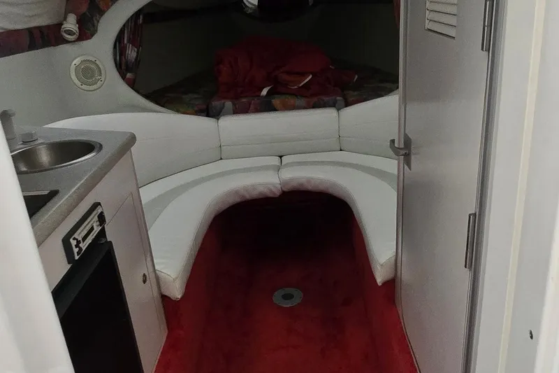 Slide: The Image of Interior of a 1997 Baja 322 boat with white seating and compact kitchenette. - 13