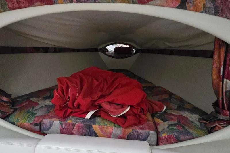 Slide: The Image of Cozy cabin interior of a 1997 Baja 322 boat with colorful bedding and red blanket. - 16