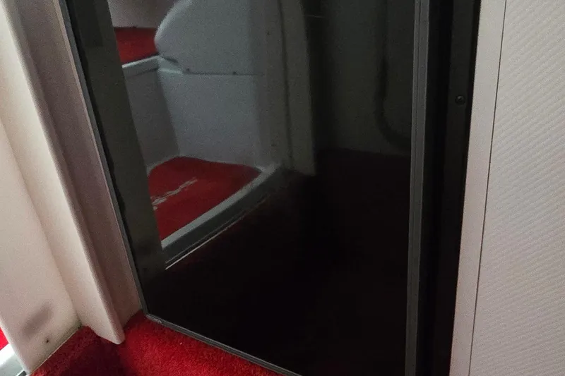 Slide: The Image of Interior of a 1997 Baja 322 boat with red carpet and seating. - 18