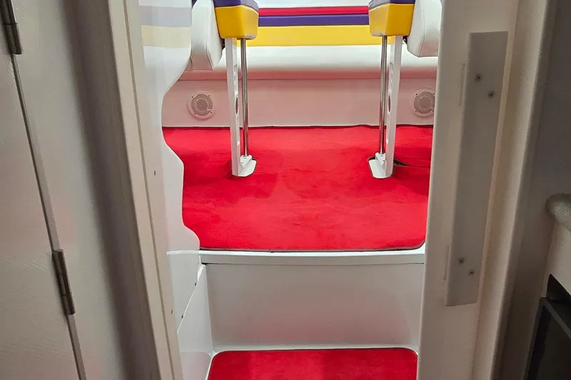 Slide: The Image of Interior of a 1997 Baja 322 boat with vibrant red carpet and colorful seating. - 19