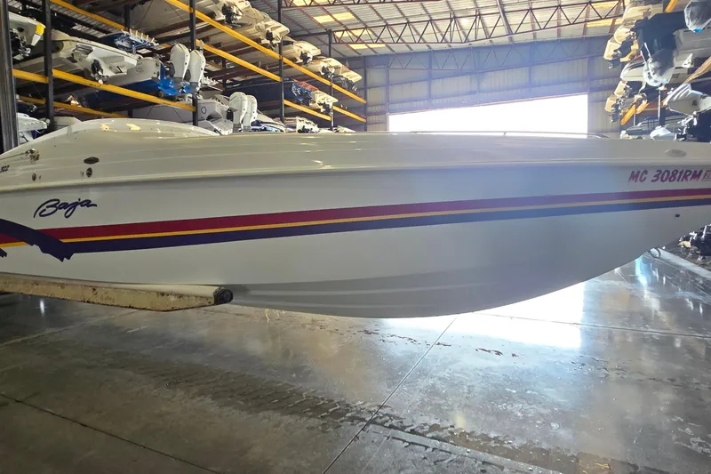 Slide: The Image of 1997 Baja 322 boat in storage, featuring sleek design and vibrant stripes. - 3