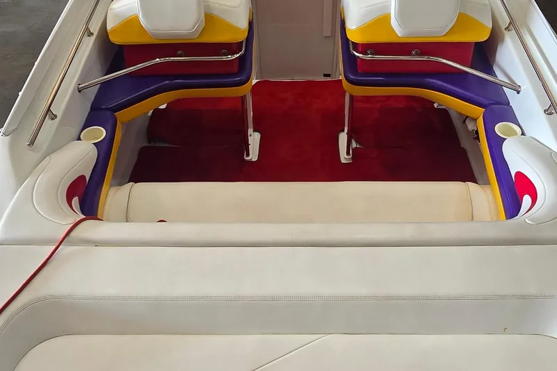 Slide: The Image of Interior of a 1997 Baja 322 boat with colorful seating and red carpet. - 5