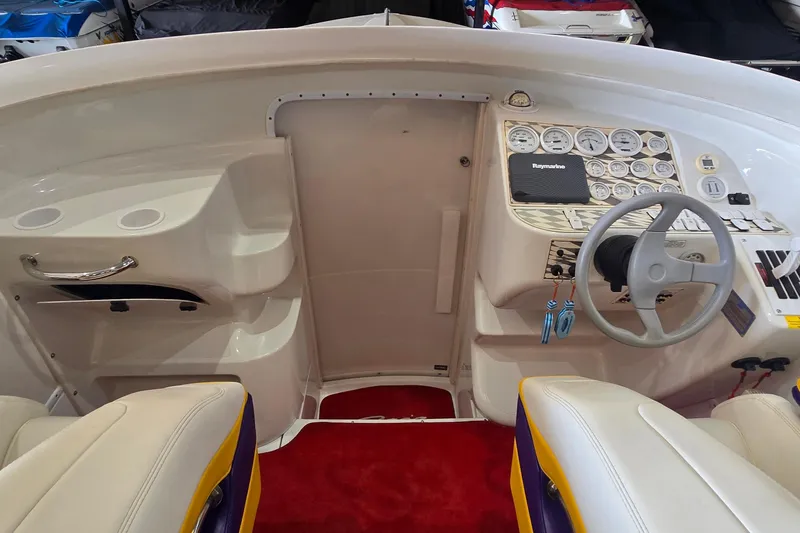 Slide: The Image of 1997 Baja 322 boat cockpit with steering wheel, gauges, and white seating. - 7