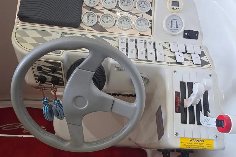 Slide: The Image of 1997 Baja 322 boat dashboard with steering wheel, gauges, and control switches. - 8