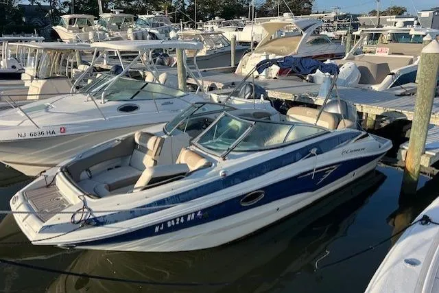The Image of 2018 Crownline Eclipse E23 XS boat docked in a marina, surrounded by other vessels. - 0