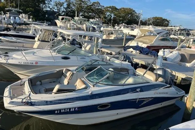 Slide: The Image of 2018 Crownline Eclipse E23 XS boat docked in a marina, surrounded by other vessels. - 3