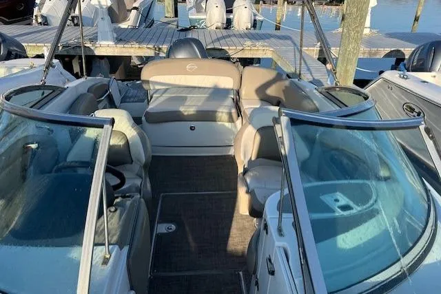 Slide: The Image of 2018 Crownline Eclipse E23 XS boat interior with seating and clear windshields at a dock. - 4