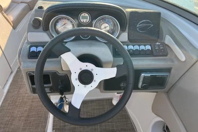 Slide: The Image of 2018 Crownline Eclipse E23 XS boat interior with beige seating and steering wheel. - 7