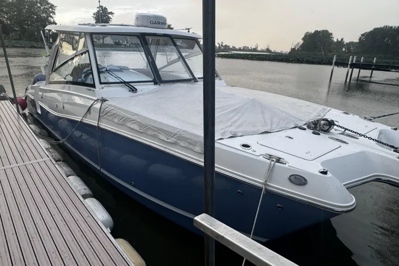 Slide: The Image of 2021 World Cat 320 DC boat docked on a calm river. - 13