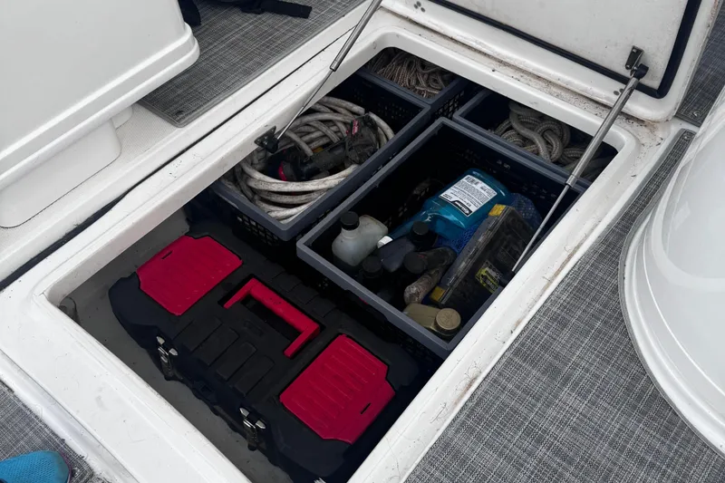 Slide: The Image of Storage compartment on a 2021 World Cat 320 DC boat with tools and supplies. - 19