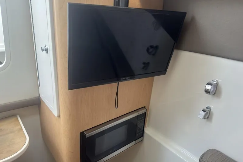 Slide: The Image of 2021 World Cat 320 DC interior with TV and microwave setup. - 23