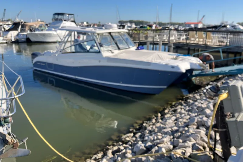 Slide: The Image of 2021 World Cat 320 DC boat docked in a marina with other vessels. - 2
