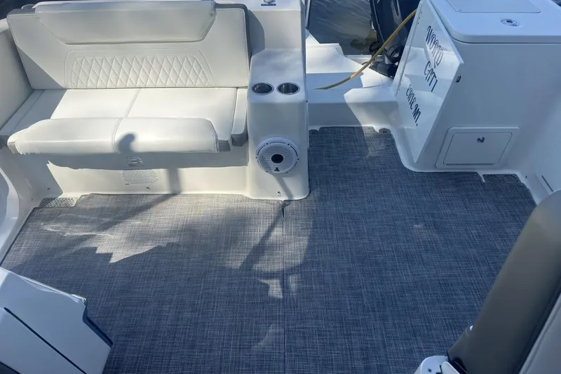 Slide: The Image of 2021 World Cat 320 DC boat interior with white seating and gray flooring. - 11