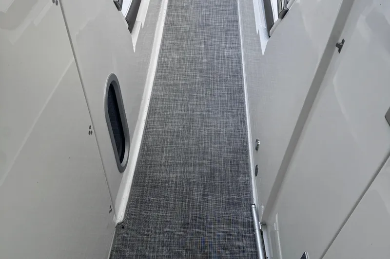 Slide: The Image of 2021 World Cat 320 DC boat interior walkway with textured flooring. - 18