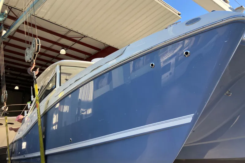 Slide: The Image of 2021 World Cat 320 DC boat in a workshop, blue hull, under maintenance. - 5