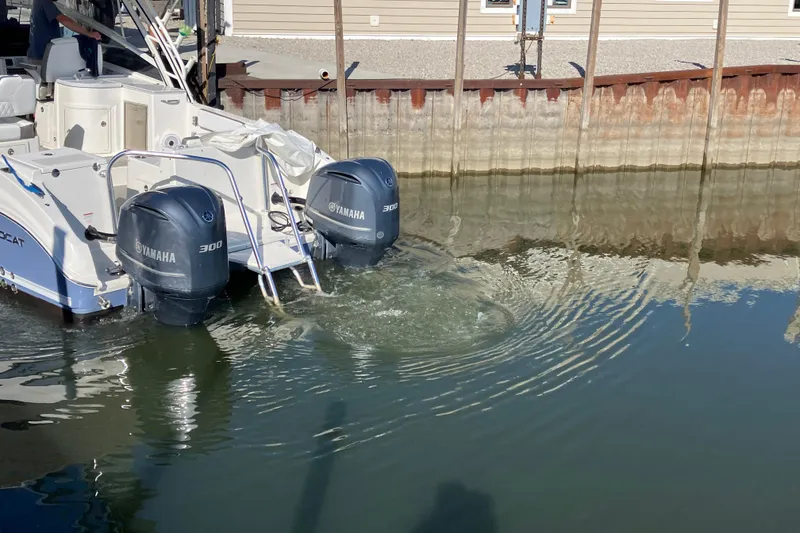 Slide: The Image of 2021 World Cat 320 DC boat with twin Yamaha 300 engines docked in calm water. - 39