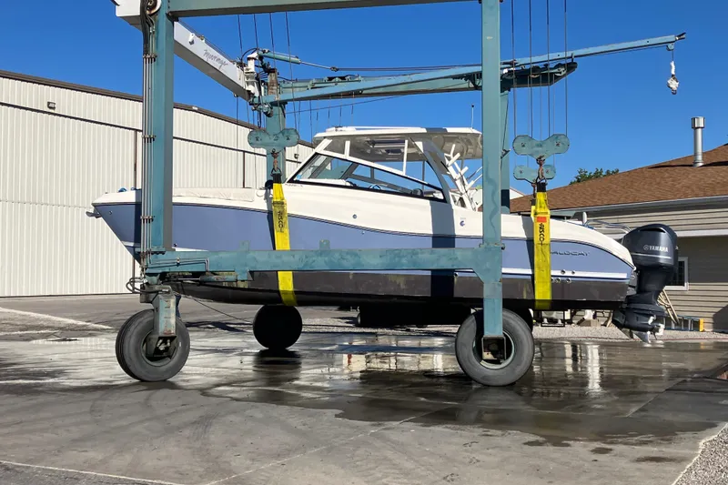 Slide: The Image of 2021 World Cat 320 DC boat lifted by crane in a marina setting. - 35