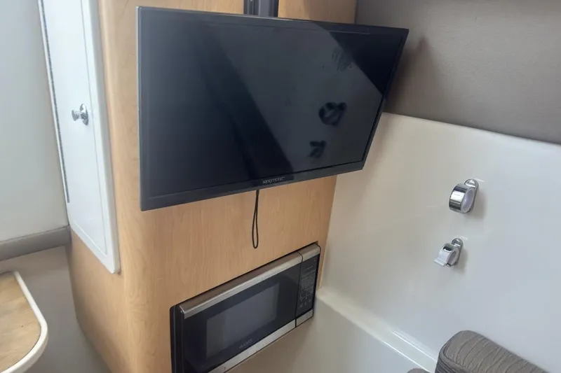 Slide: The Image of Interior of 2021 World Cat 320 DC featuring a mounted TV and microwave. - 24