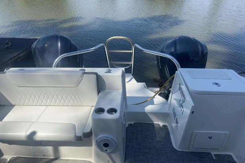 Slide: The Image of 2021 World Cat 320 DC boat with dual engines and seating, docked on calm water. - 10