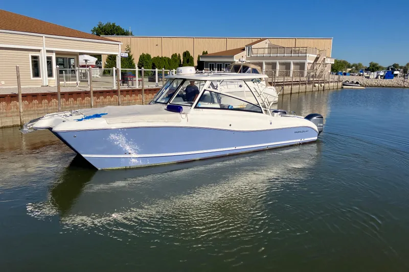 The Image of 2021 World Cat 320 DC boat docked in a marina under clear blue skies. - 0