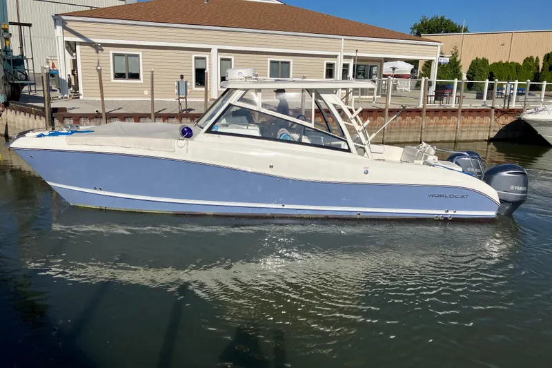 Slide: The Image of 2021 World Cat 320 DC boat docked in marina, featuring sleek design and dual engines. - 1