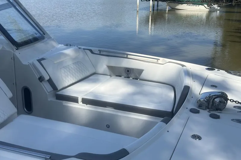 Slide: The Image of 2021 World Cat 320 DC boat interior with cushioned seating by the water. - 9