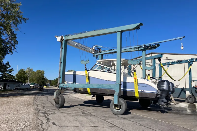 Slide: The Image of 2021 World Cat 320 DC boat lifted by a crane in a marina setting. - 34
