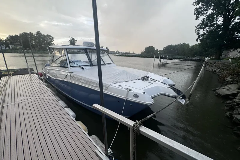 Slide: The Image of 2021 World Cat 320 DC boat docked on a calm river. - 27