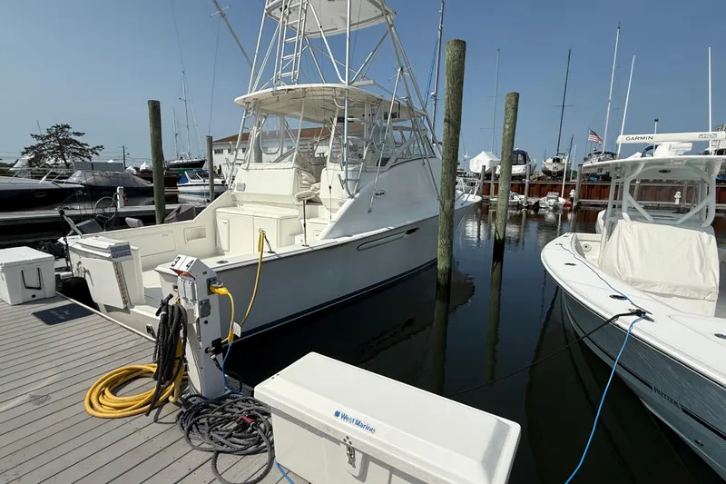 The Image of 1999 Ocean Yachts 40 Express docked at marina, surrounded by other boats. - 0
