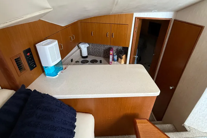 Slide: The Image of 1999 Ocean Yachts 40 Express interior kitchen with wooden cabinets and modern appliances. - 12