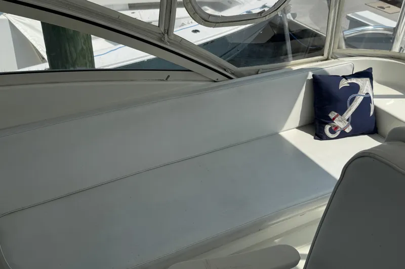Slide: The Image of 1999 Ocean Yachts 40 Express interior with white seating and anchor-themed pillow. - 13