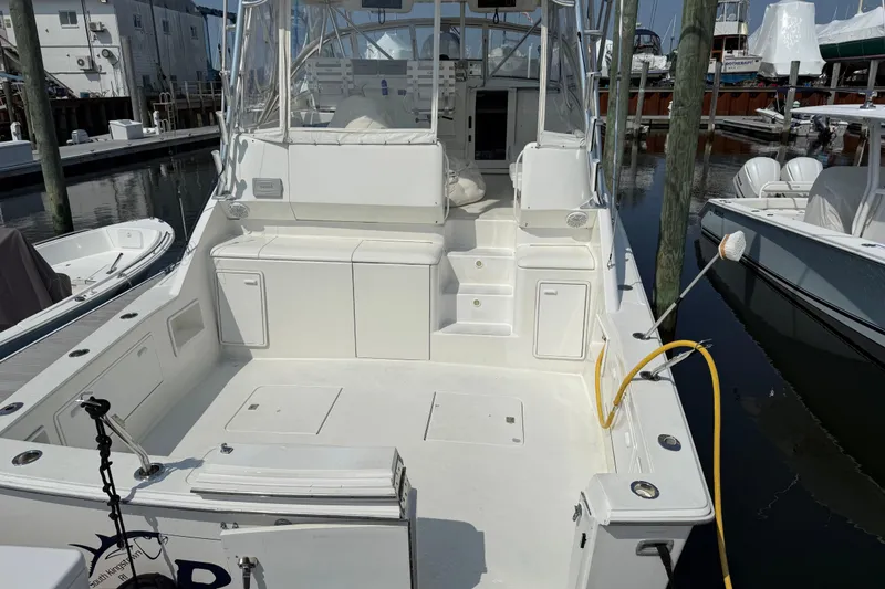 Slide: The Image of 1999 Ocean Yachts 40 Express boat docked, featuring spacious deck and seating area. - 14
