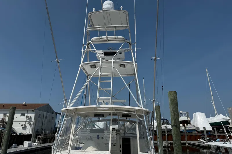 Slide: The Image of 1999 Ocean Yachts 40 Express boat docked at marina under clear blue sky. - 17