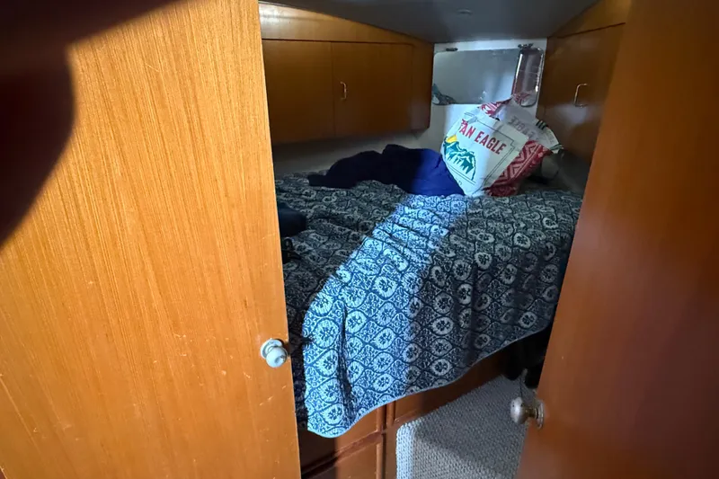 Slide: The Image of 1999 Ocean Yachts 40 Express cabin with blue patterned bedding and wooden cabinetry. - 7
