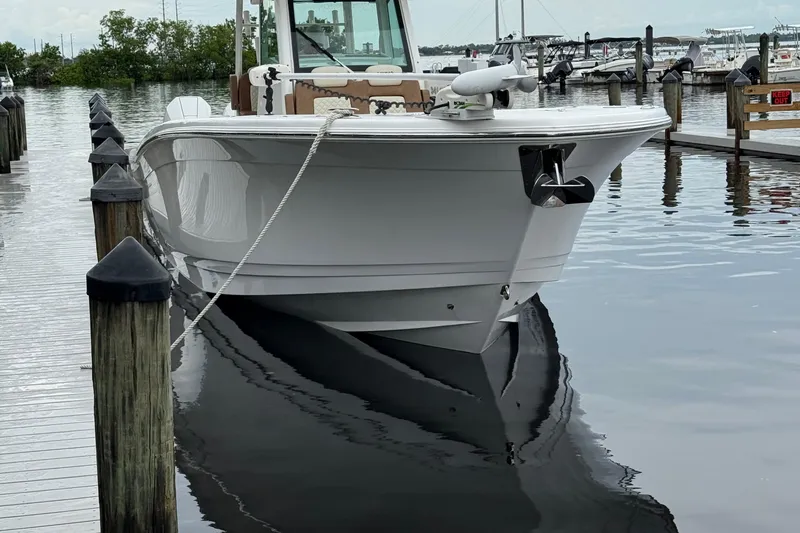 Slide: The Image of 2020 Caymas 341 CC boat docked at marina, calm water reflection. - 13