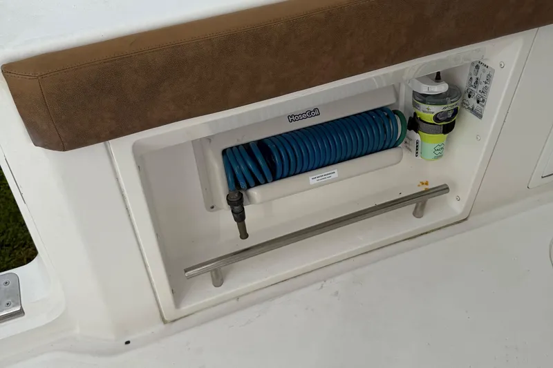 Slide: The Image of Storage compartment on 2020 Caymas 341 CC boat with hose and cleaning supplies. - 20