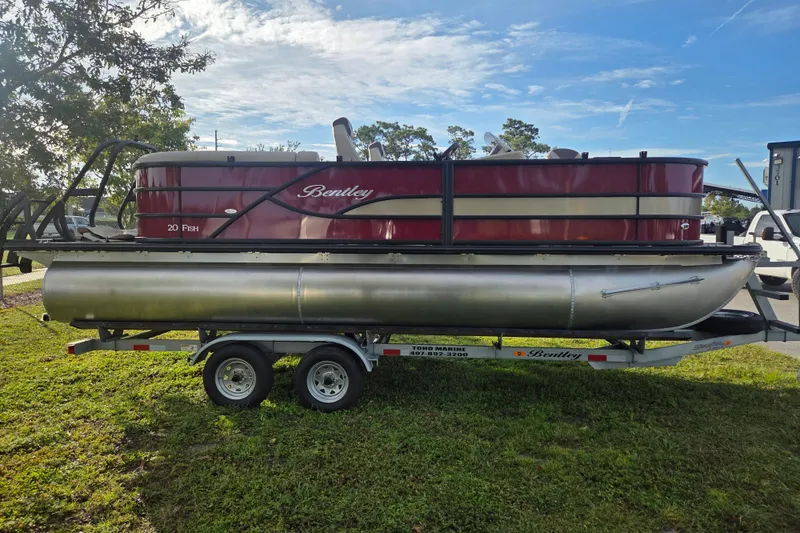 Slide: The Image of 2026 Bentley Pontoons Fish 203 on trailer, parked on grass under clear sky. - 12