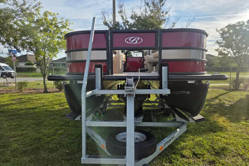 Slide: The Image of 2026 Bentley Pontoons Fish 203 on trailer, red exterior, parked on grass. - 8