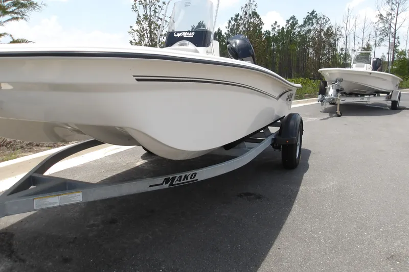 Slide: The Image of 2026 Mako Pro Skiff 15 CC boat on trailer, parked on a road. - 14