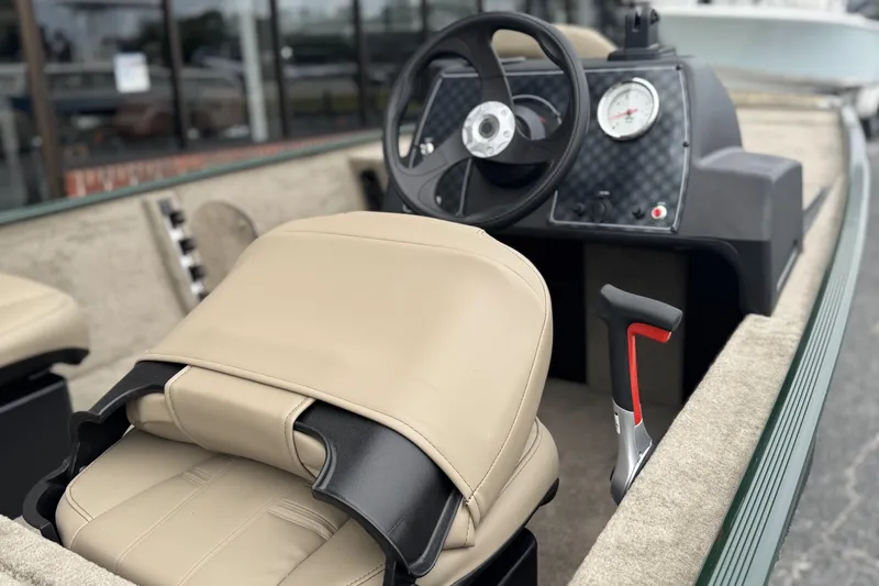 Slide: The Image of 2026 Tracker Bass Tracker Classic Limited boat interior with steering wheel and beige seating. - 5