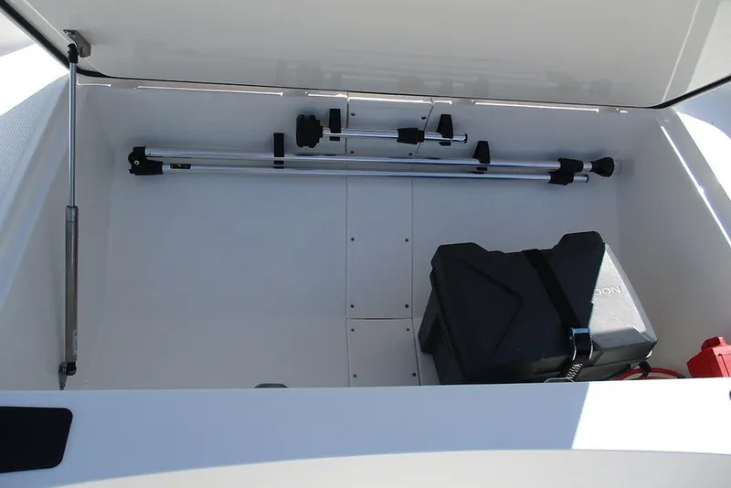 Slide: The Image of Storage compartment of 2026 Mako Pro Skiff 15 CC boat, featuring equipment and battery. - 14