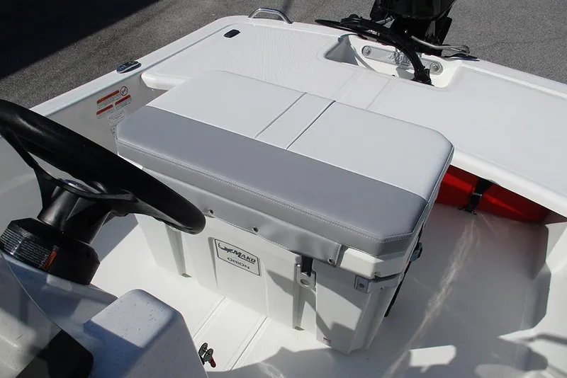 Slide: The Image of 2026 Mako Pro Skiff 15 CC boat interior with steering wheel and cushioned seat. - 18