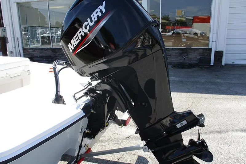 Slide: The Image of 2026 Mako Pro Skiff 15 CC with Mercury outboard motor in a showroom setting. - 9