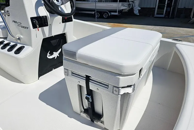 Slide: The Image of 2026 Mako Pro Skiff 15 CC boat interior with cushioned seat and steering console. - 10