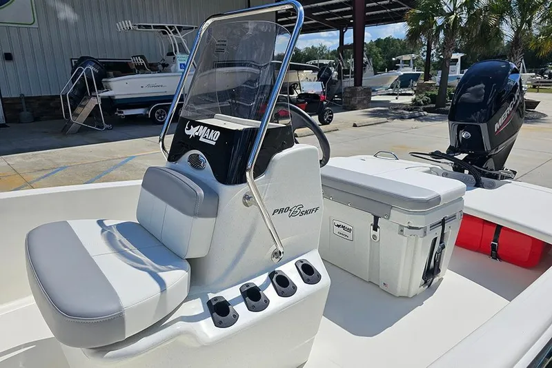 Slide: The Image of 2026 Mako Pro Skiff 15 CC boat with seating and console, displayed outdoors. - 12
