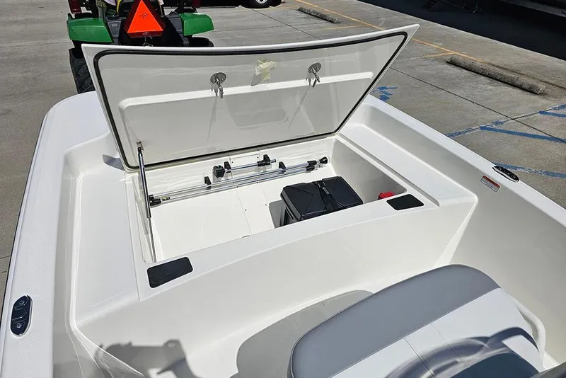 Slide: The Image of 2026 Mako Pro Skiff 15 CC boat storage compartment open, showcasing interior space. - 15