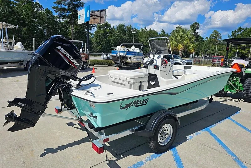 Slide: The Image of 2026 Mako Pro Skiff 15 CC boat with Mercury engine on trailer, parked outdoors. - 7