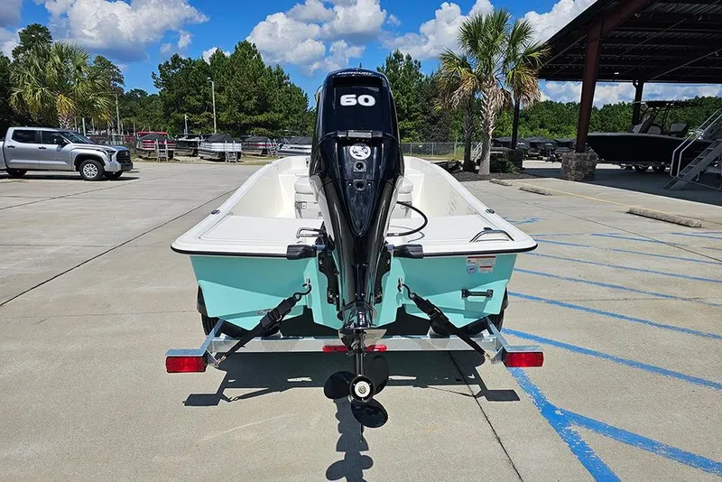 Slide: The Image of 2026 Mako Pro Skiff 15 CC boat on trailer, parked outdoors under blue sky. - 8
